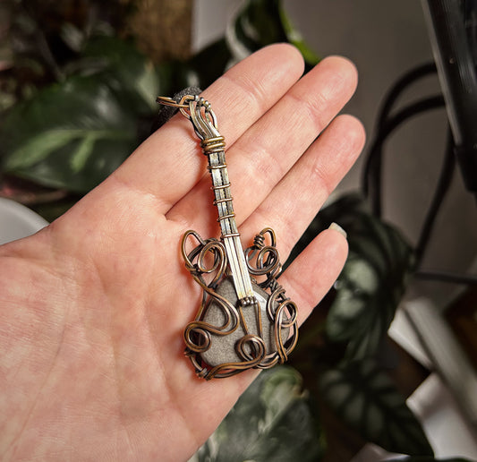 Copper and silver wire guitar over silver obsidian stone