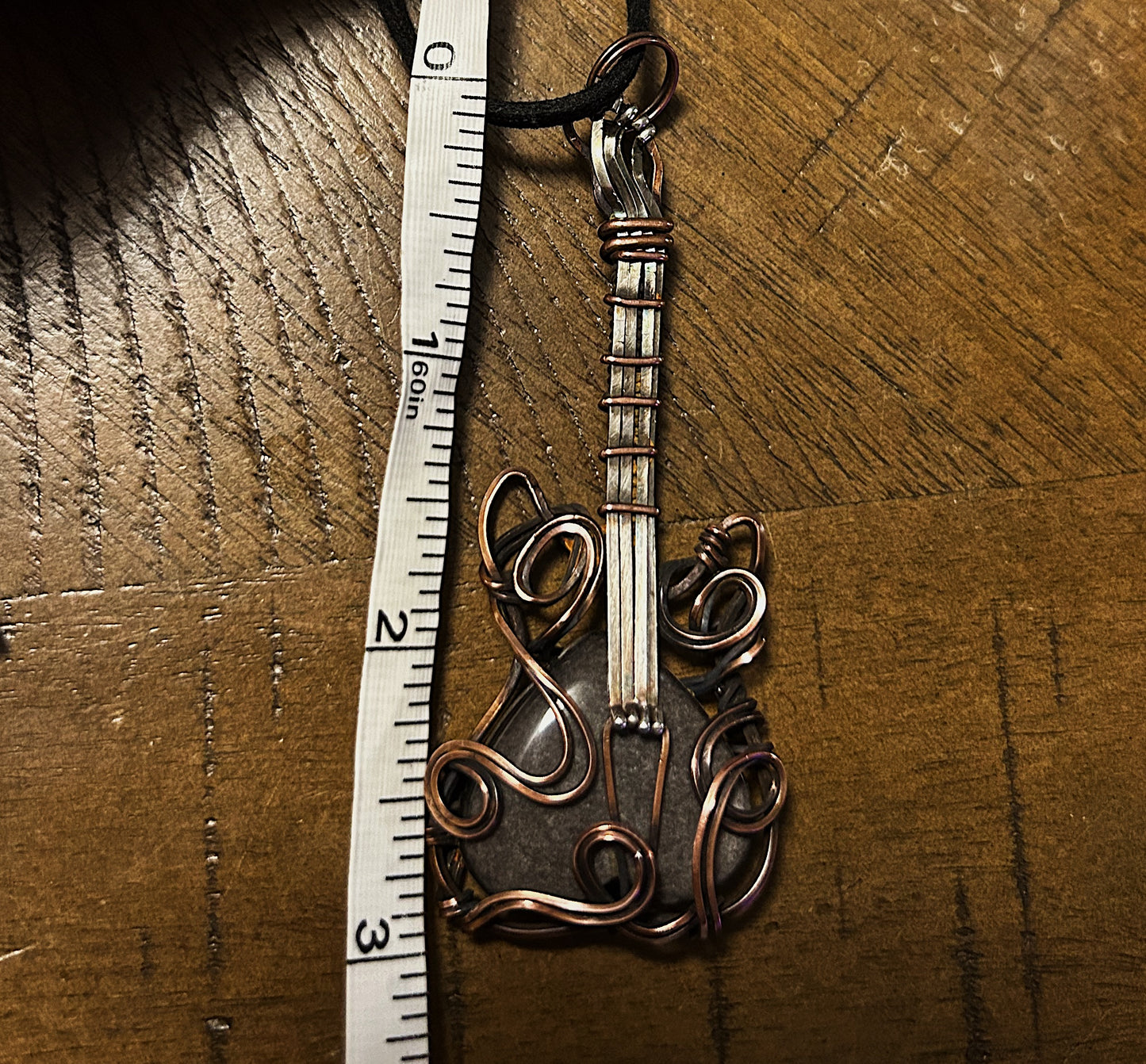 Copper and silver wire guitar over silver obsidian stone